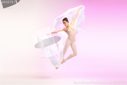 Image of Ballerina. Young graceful female ballet dancer dancing over pink studio. Beauty of classic ballet.