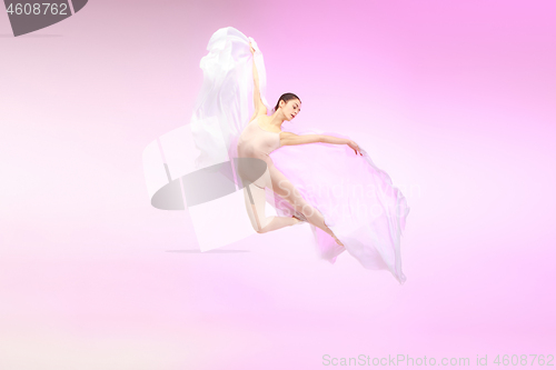 Image of Ballerina. Young graceful female ballet dancer dancing over pink studio. Beauty of classic ballet.