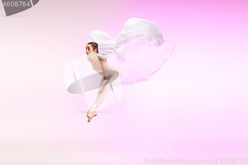 Image of Ballerina. Young graceful female ballet dancer dancing over pink studio. Beauty of classic ballet.