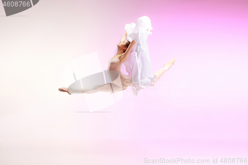 Image of Ballerina. Young graceful female ballet dancer dancing over pink studio. Beauty of classic ballet.