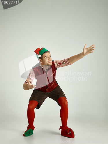 Image of friendly man dressed like a funny gnome posing on an isolated gray background