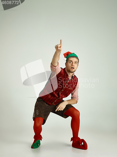 Image of friendly man dressed like a funny gnome posing on an isolated gray background