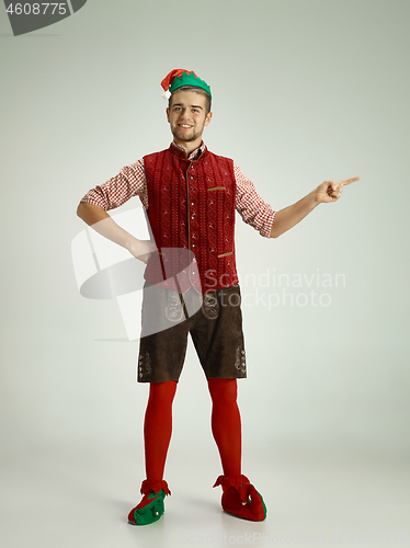 Image of friendly man dressed like a funny gnome posing on an isolated gray background