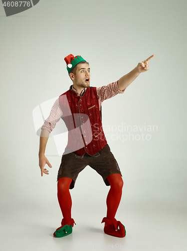 Image of friendly man dressed like a funny gnome posing on an isolated gray background