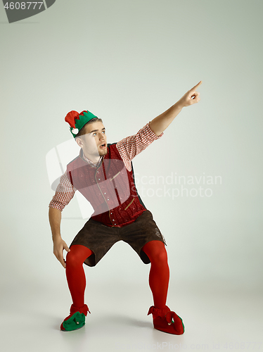 Image of friendly man dressed like a funny gnome posing on an isolated gray background