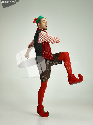 Image of friendly man dressed like a funny gnome posing on an isolated gray background