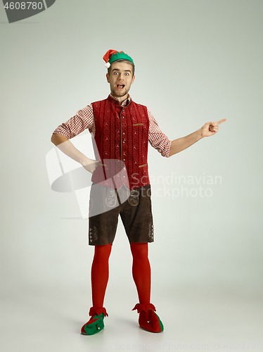 Image of friendly man dressed like a funny gnome posing on an isolated gray background