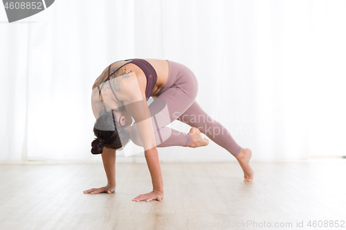 Image of Portrait of gorgeous active sporty young woman practicing yoga in studio. Beautiful girl practice Sasangasana, rabbit yoga pose. Healthy active lifestyle, working out indoors in gym