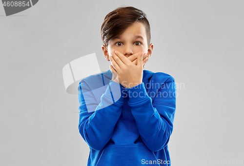 Image of shocked boy closing mouth by hands