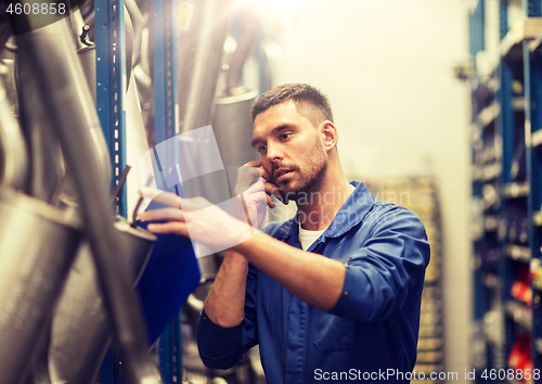 Image of auto mechanic with clipboard at car workshop