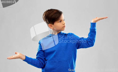 Image of boy in blue holding something on empty hands