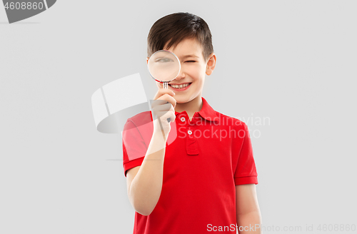 Image of smiling boy looking through magnifying glass