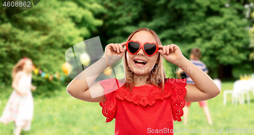 Image of happy girl with heart shaped sunglasses at party