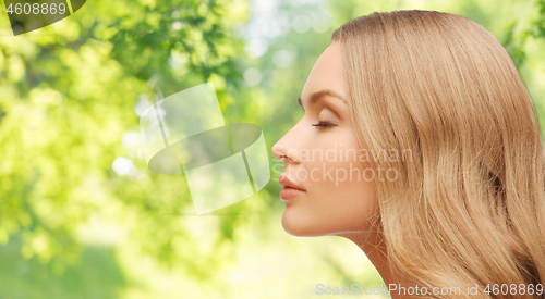 Image of beautiful young woman face over natural background