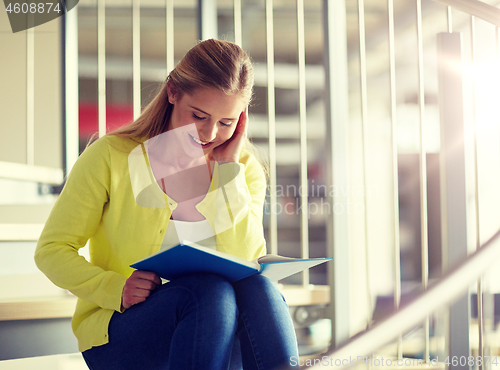 Image of smiling high school student girl reading book