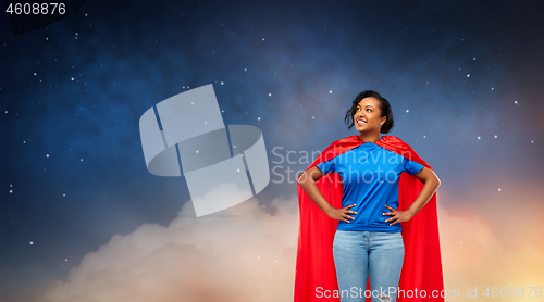 Image of happy african american woman in superhero red cape