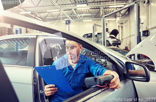 Image of mechanic man with diagnostic scanner at car shop