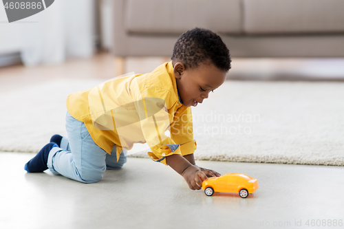 Image of african american baby boy playing with toy car
