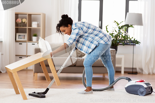 Image of woman or housewife with vacuum cleaner at home