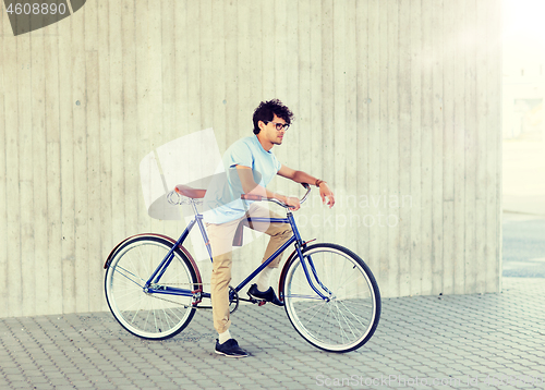 Image of young hipster man riding fixed gear bike