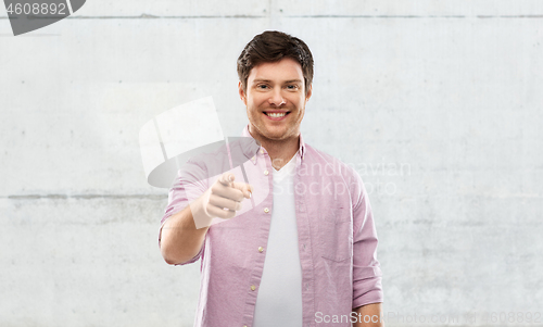 Image of smiling man pointing fingers at you