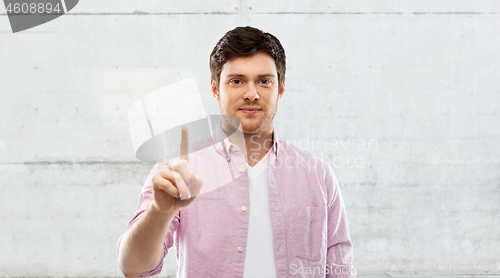 Image of young man showing one finger over grey background