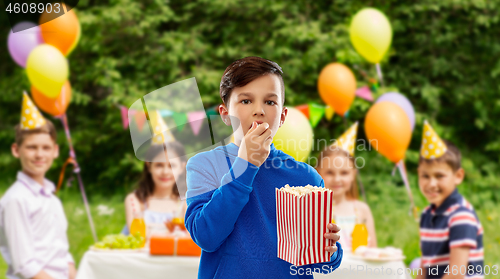 Image of boy eating popcorn at birthday party