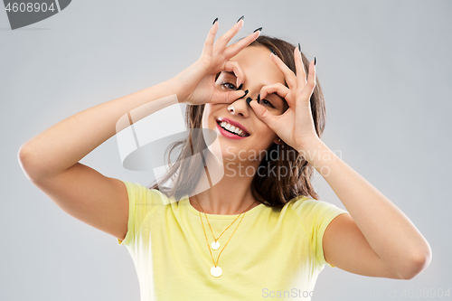 Image of young woman looking through finger glasses