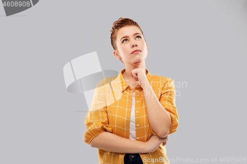 Image of red haired teenage girl looking up and dreaming