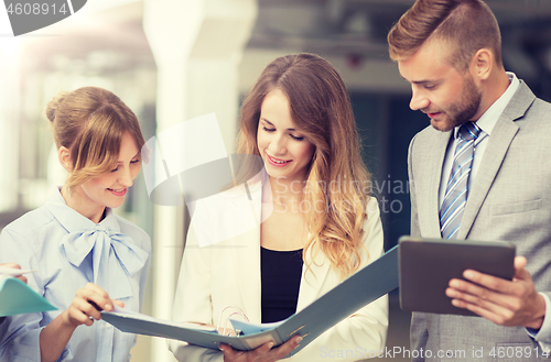 Image of business team with tablet pc and folders at office