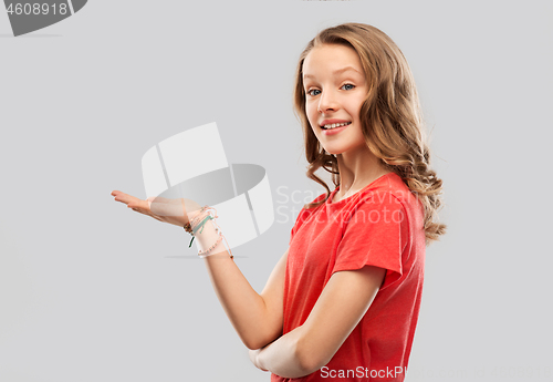 Image of smiling teenage girl holding empty hand