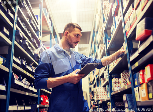 Image of auto mechanic or smith with tablet pc at workshop