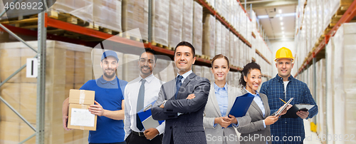 Image of group of business people and warehouse workers