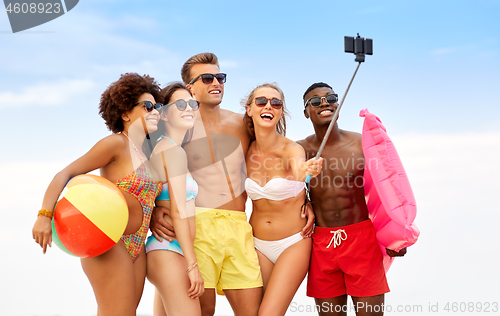 Image of happy friends taking selfie on summer beach