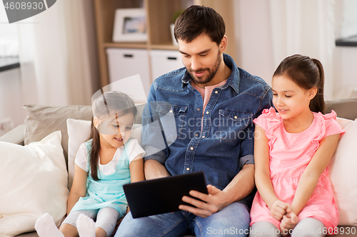 Image of happy father and daughters with tablet pc at home