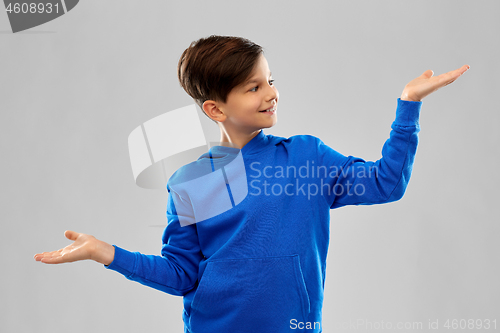 Image of boy in blue holding something on empty hands