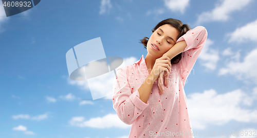 Image of sleepy woman in pajama napping over sky