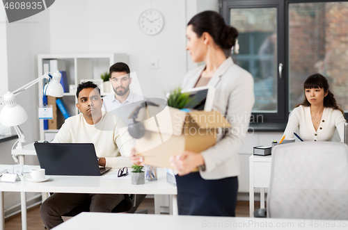 Image of female office worker with box of personal stuff