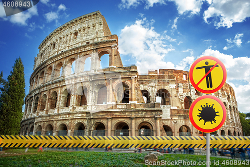 Image of Warning signs with Coronavirus molecule and crossed out man on a background of Colosseum in Rome, Italy.