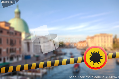 Image of Warning sign with Coronavirus molecule on a police line on the blurred background of Grand Canal in Venice, Italy.