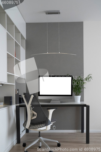 Image of Home working place with modern desk and mock-up computer monitor.