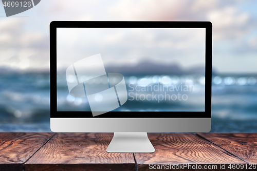 Image of Computer display with blurred sea background.