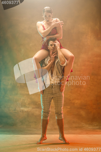 Image of Flexible young modern dance couple posing in studio.