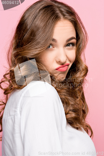 Image of Suspiciont. Doubtful pensive woman with thoughtful expression making choice against pink background