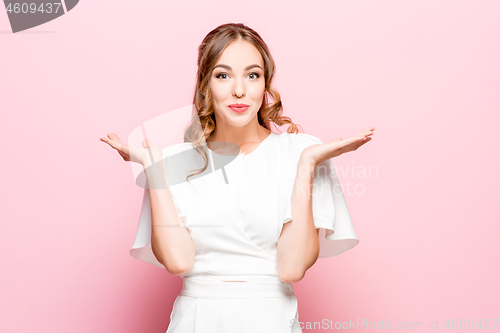 Image of Beautiful woman looking suprised isolated on pink