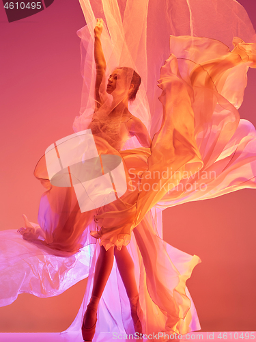 Image of Ballerina. Young graceful female ballet dancer dancing over red studio. Beauty of classic ballet.