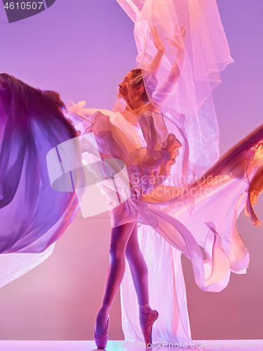 Image of Ballerina. Young graceful female ballet dancer dancing over pink studio. Beauty of classic ballet.