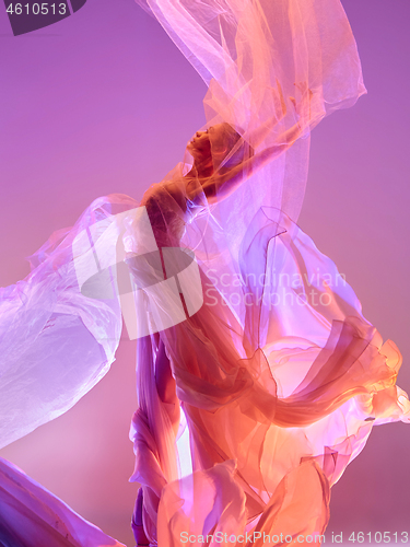 Image of Ballerina. Young graceful female ballet dancer dancing over pink studio. Beauty of classic ballet.