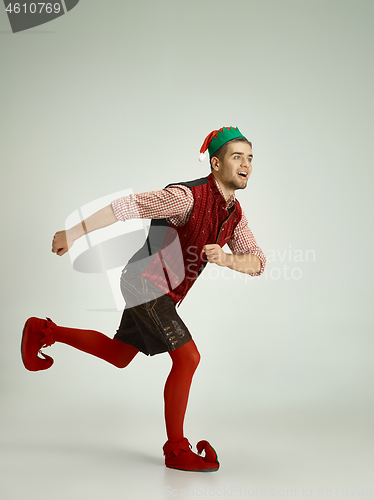 Image of friendly man dressed like a funny gnome posing on gray background