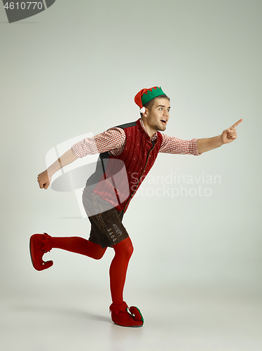 Image of friendly man dressed like a funny gnome posing on gray background